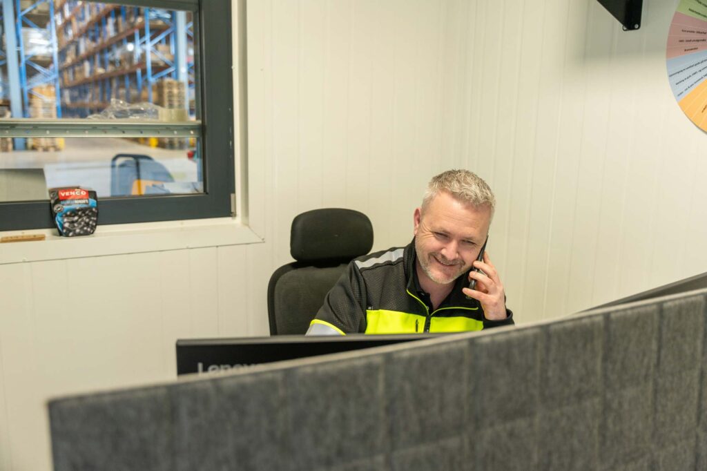 Foto av mann som sitter i telefon, snakker om godstransport norge